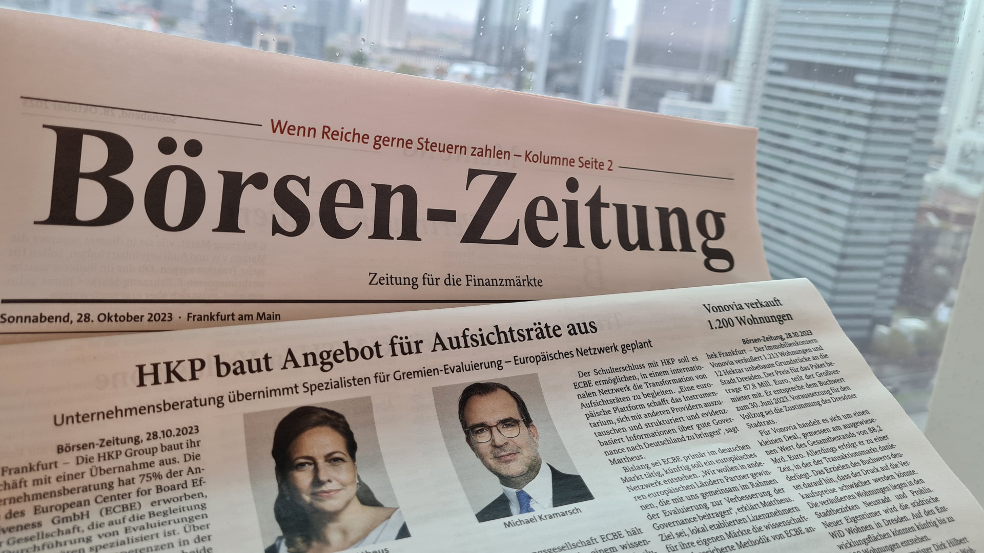 Die Print-Ausgabe der Börsen-Zeitung vor der Frankfurter Skyline. Zu lesen ist die Überschrift: hkp/// group baut Angebot für Aufsichtsräte aus.